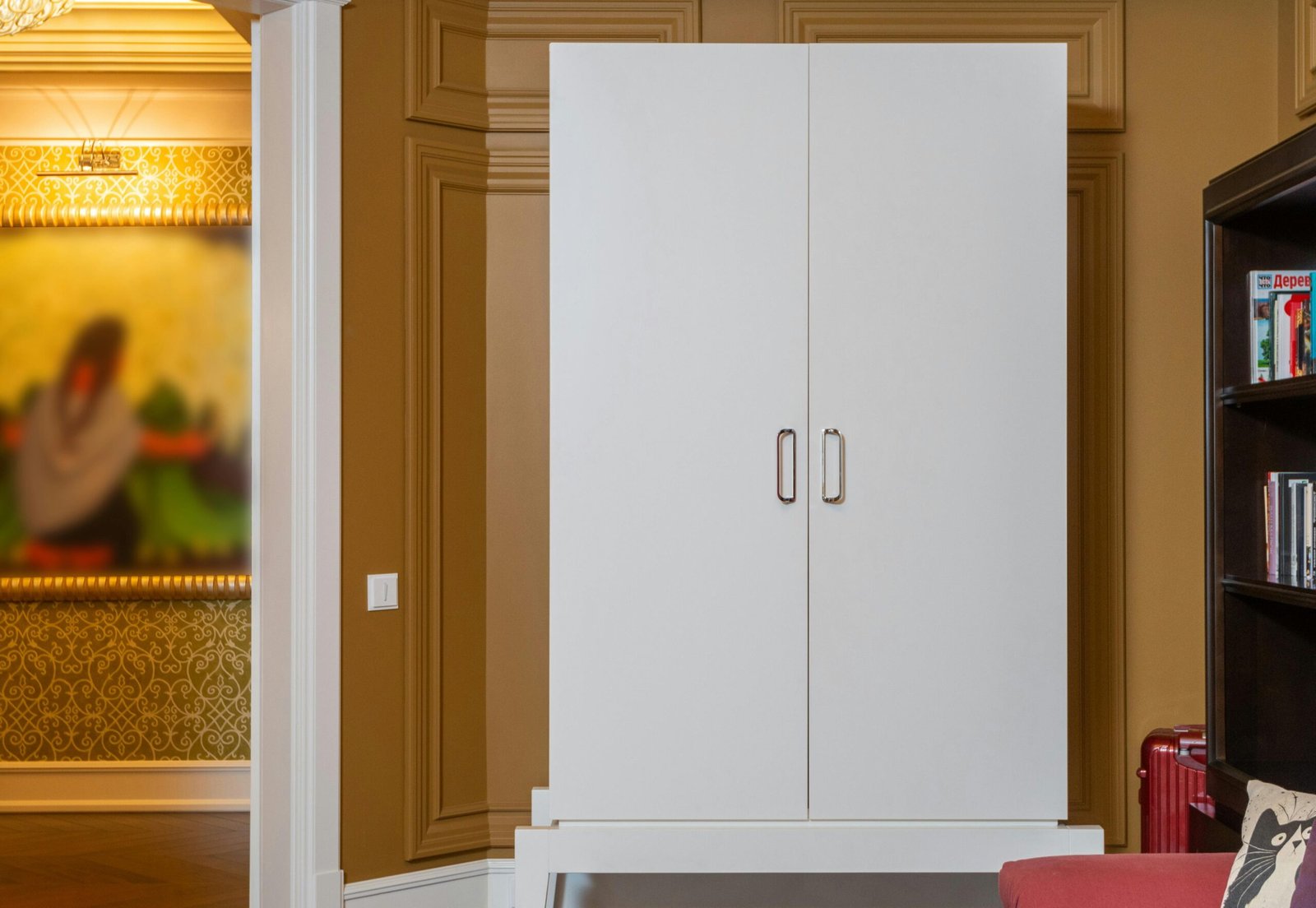 Sleek white wardrobe in a luxurious, modern interior with elegant wood paneling and decor.
